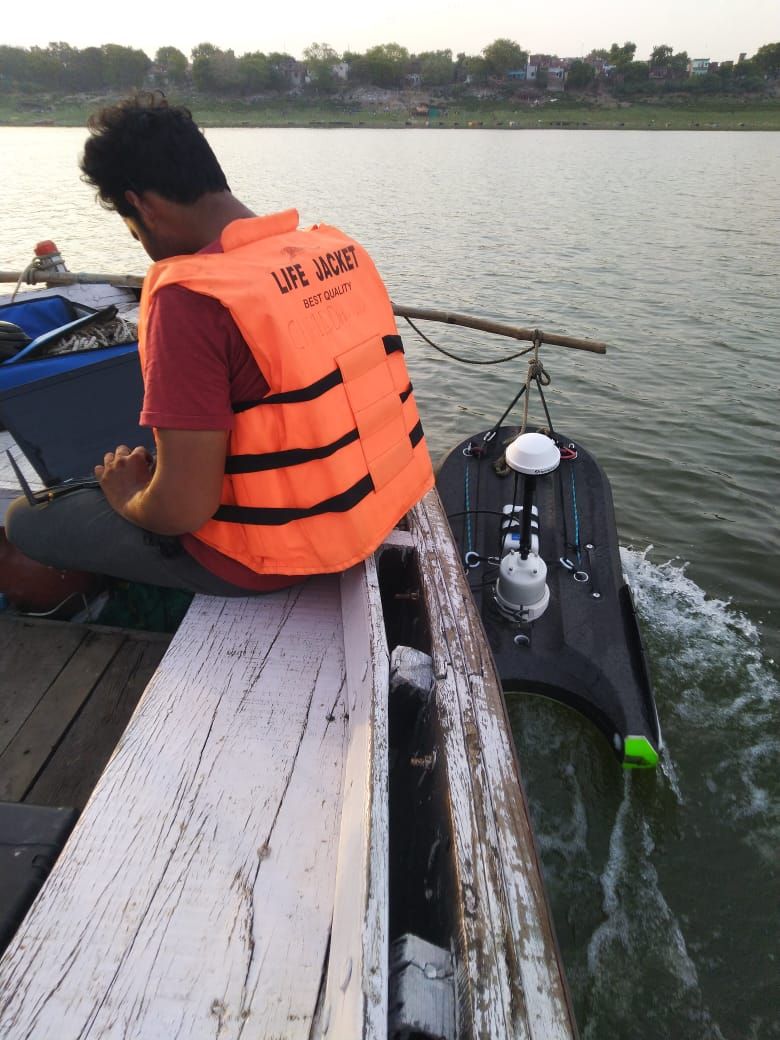 An acoustic Doppler current profiler mounted on a small survey vessel being towed on a river