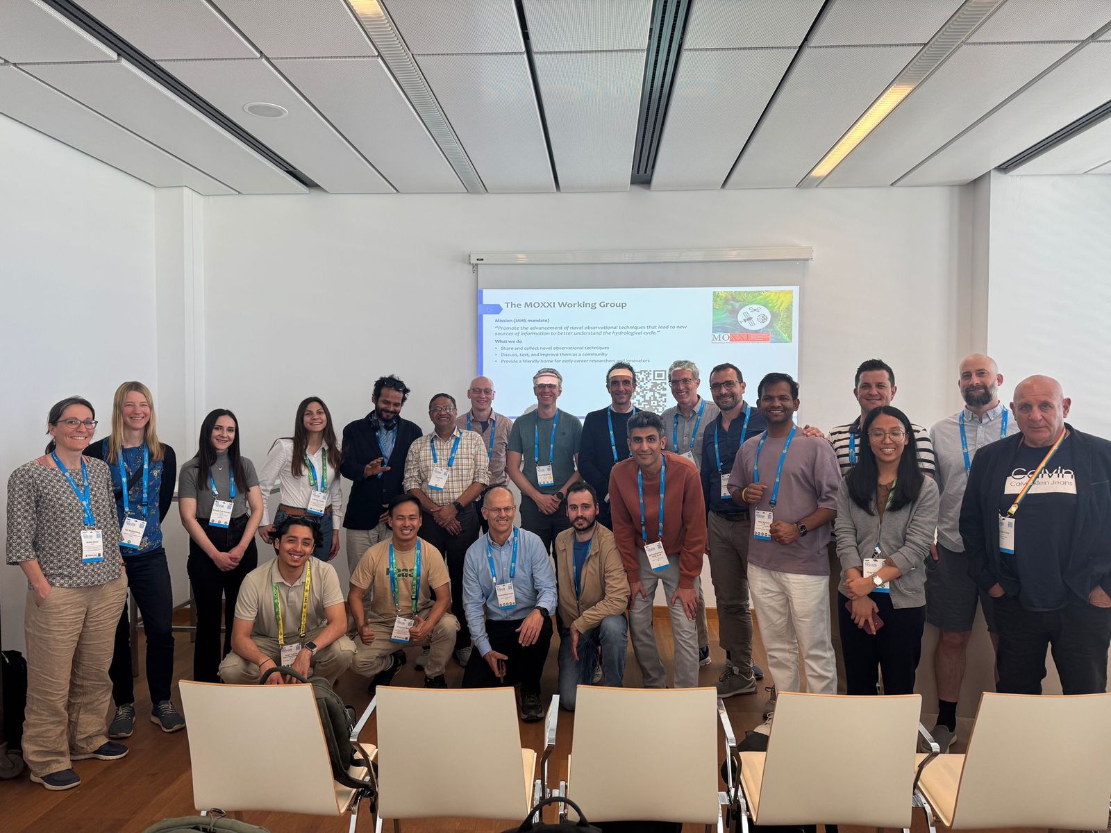 The MOXXI working group gathered in front of a presentation slide at a conference